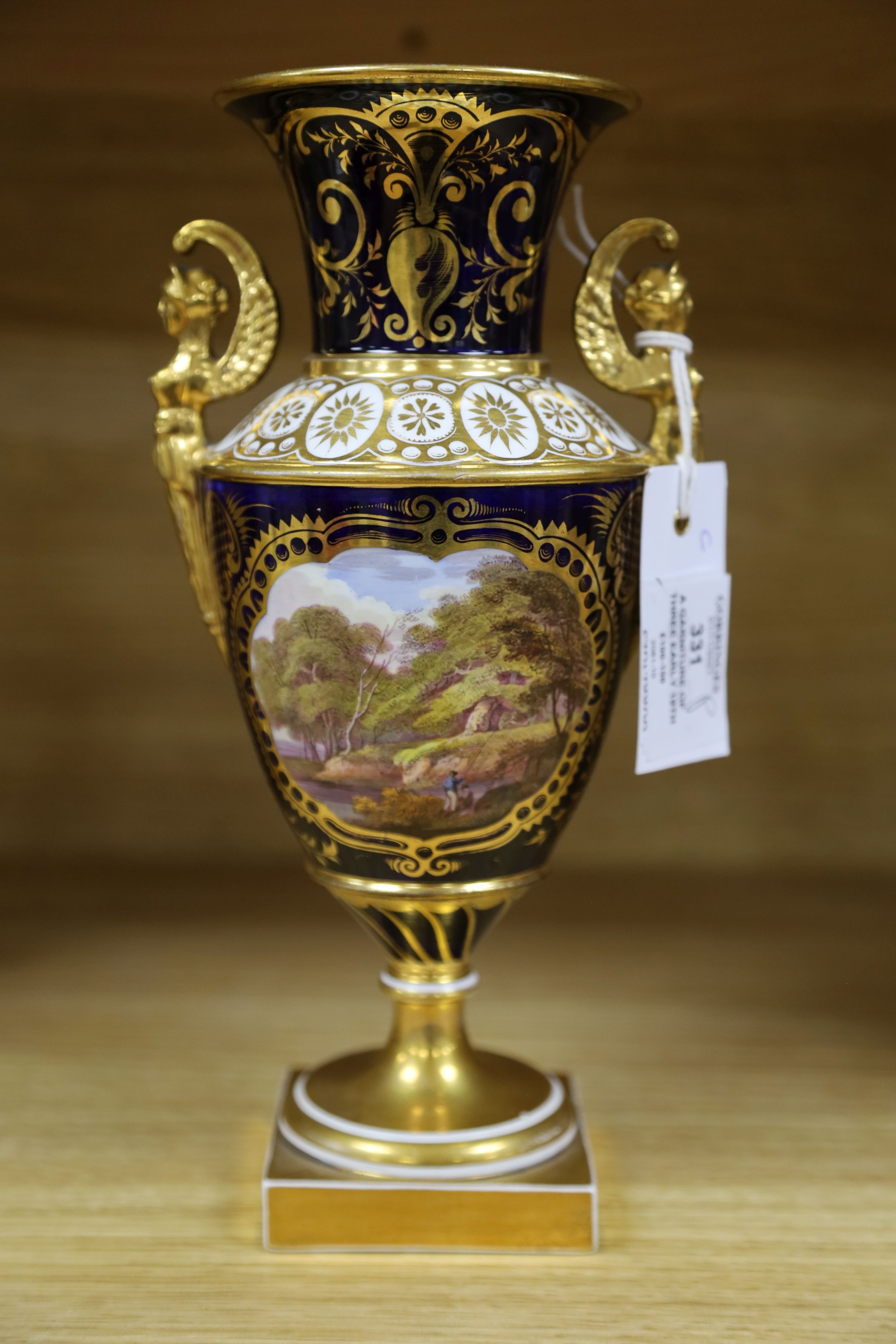 A garniture of three early 19th century English porcelain vases, c.1815-20, each painted with topographical views, tallest 26cm